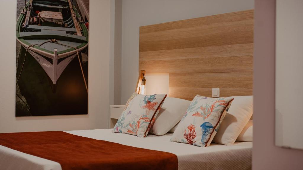 塞博河畔卡莱塔La Pardela Experience Apartamentos的配有两张枕头的床的酒店客房