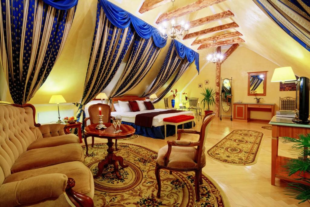 锡比乌康瑟尔酒店的一间卧室配有一张床、一张沙发和一张桌子
