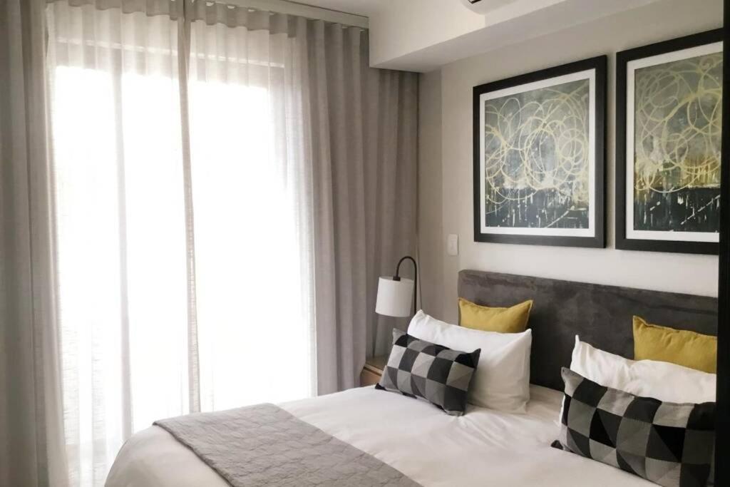 比勒陀利亚Regency Apartment Hotel Menlyn的一间卧室配有一张带黑白枕头的床
