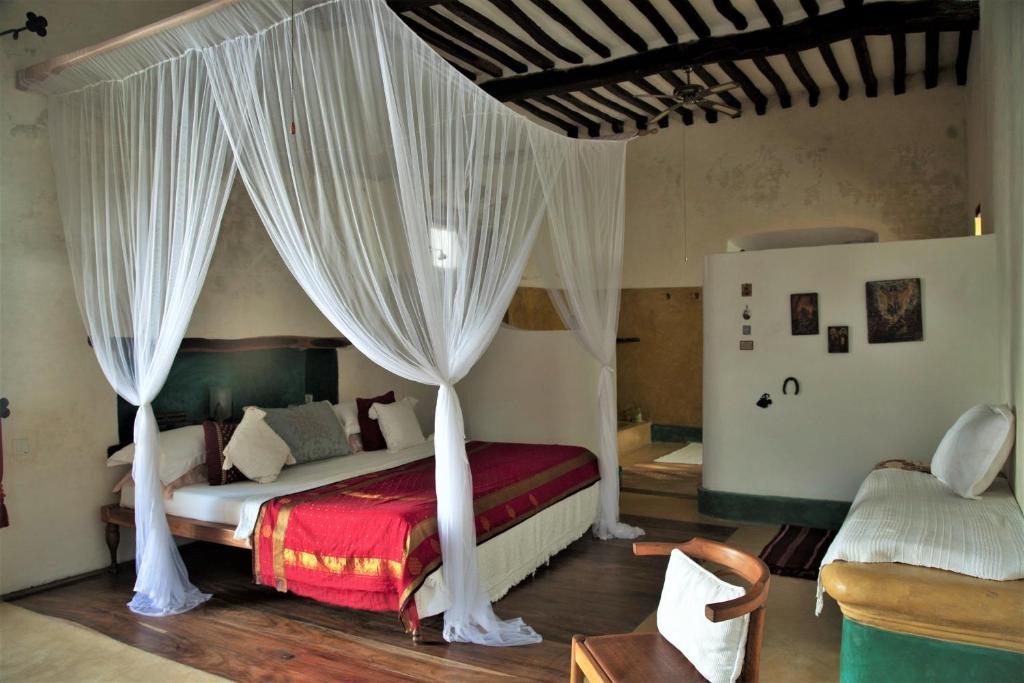 莫桑比克岛Jardim dos Aloés, Unique B&B - Casa de Charme的一间卧室配有带窗帘的天蓬床