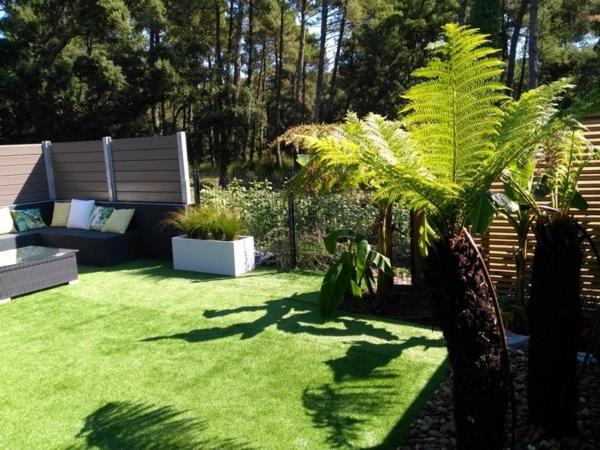 塞尼奥斯Villa patio terrasse privative océan 10 min a pied的一个带沙发和棕榈树的绿色庭院
