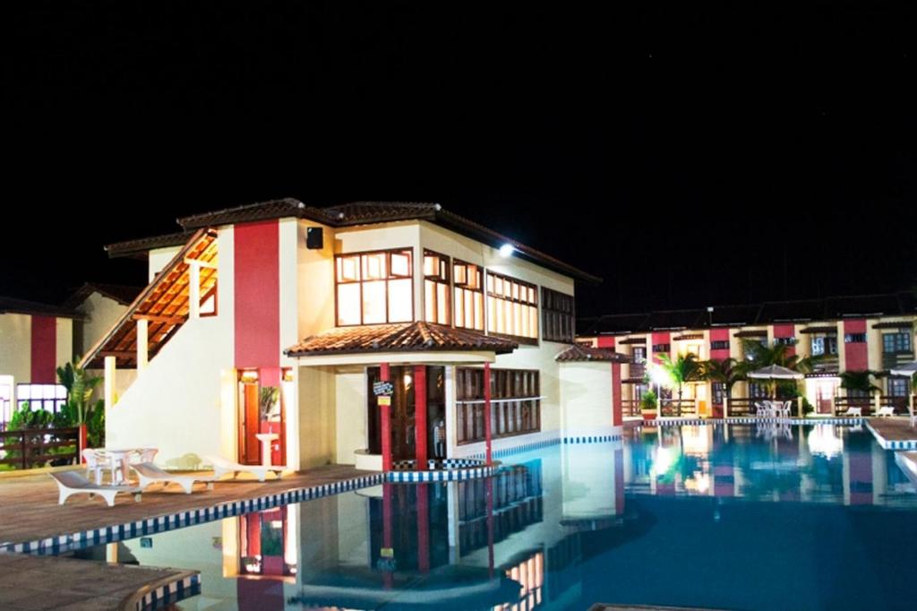 塞古罗港Meu Porto Seguro - Taperapuã的一座晚上设有游泳池的房子