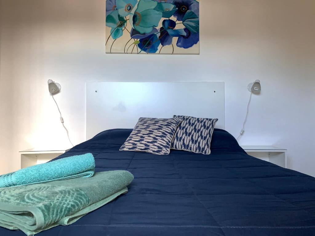 胡宁Las Hortensias的一张带蓝色床单的床和两个枕头