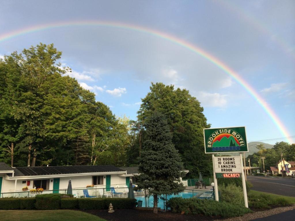 乔治湖Brookside Motel & Cabins的天上一带标志的房子上的彩虹