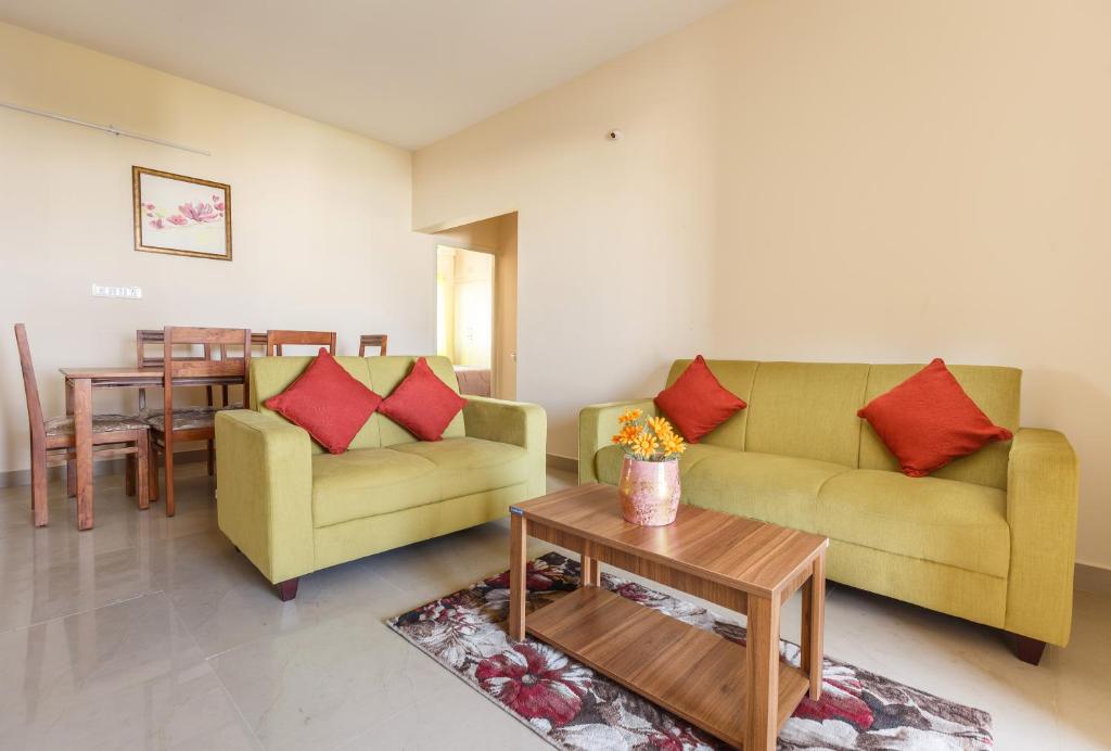 班加罗尔Misty Meridian Serviced Apartments的客厅配有两张沙发和一张桌子