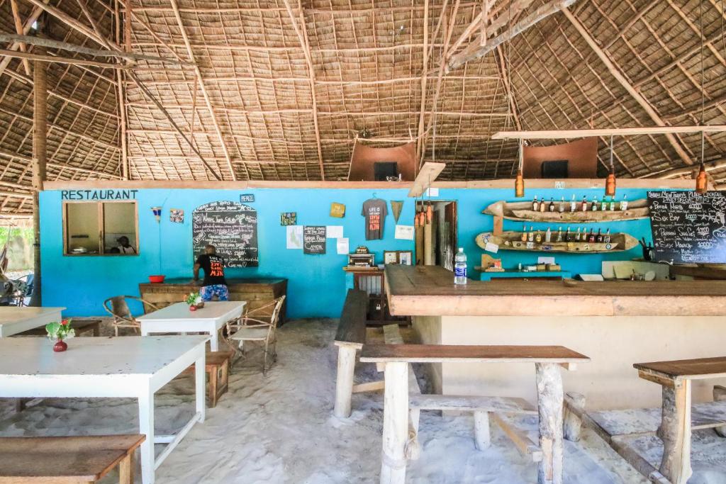 帕杰Your Zanzibar Place的一间带桌椅和蓝色墙壁的餐厅