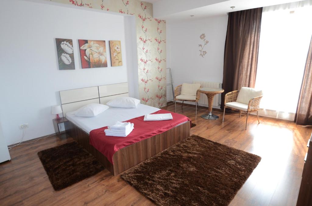 布加勒斯特Mosilor Apartments的一间卧室配有一张带红色毯子的大床