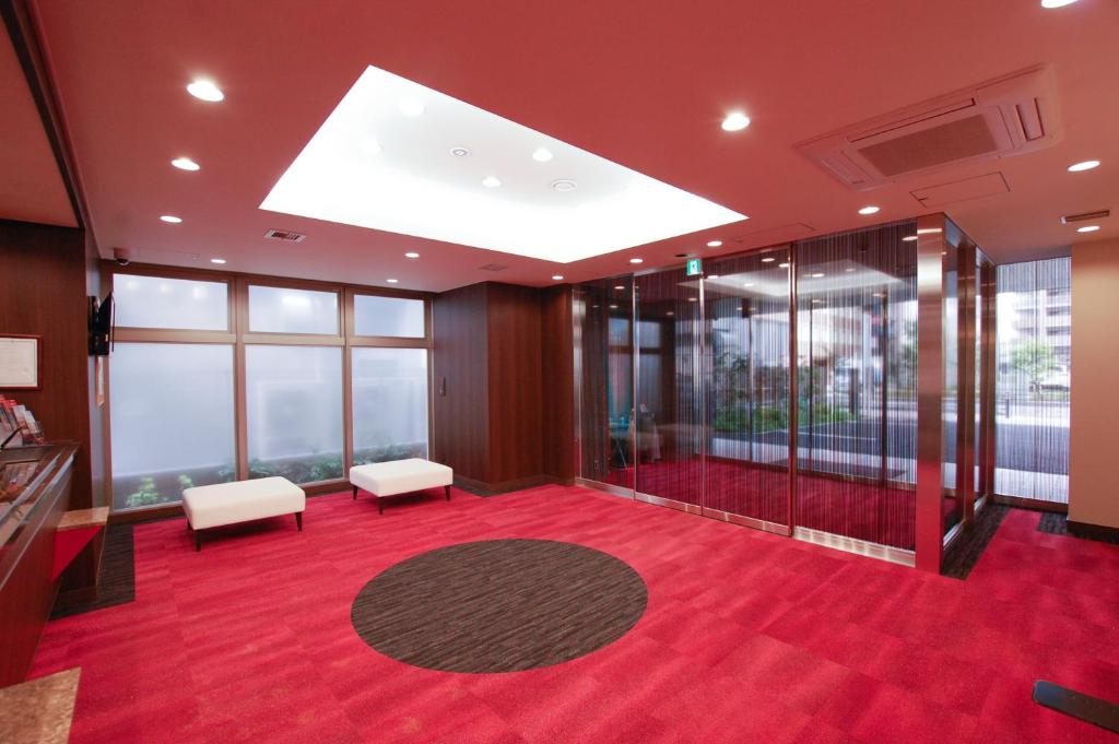 相模原市AI HOTEL Hashimoto的一间大客房,铺有红地毯,设有窗户。