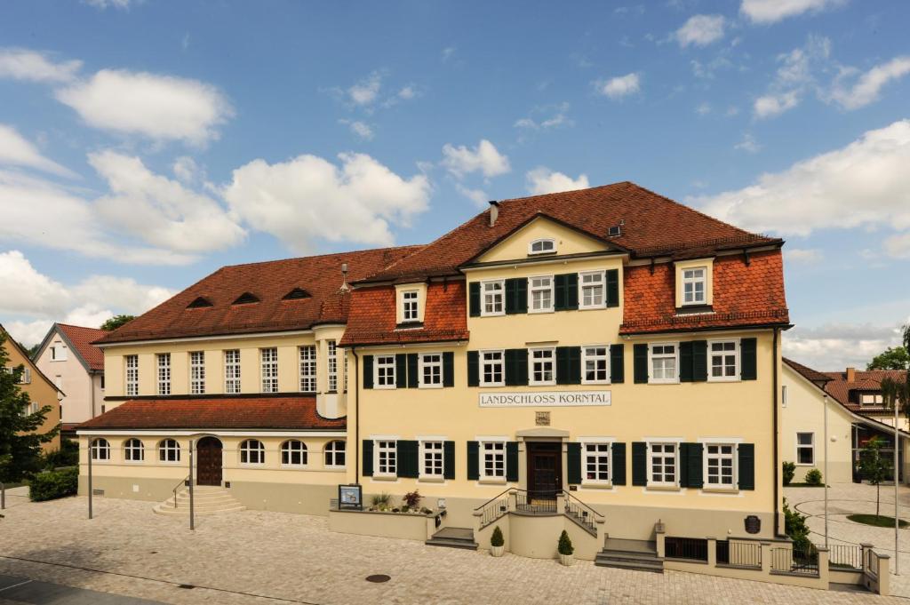 科尔恩塔尔-明欣根Landschloss Korntal的白色的大建筑,带有棕色的屋顶