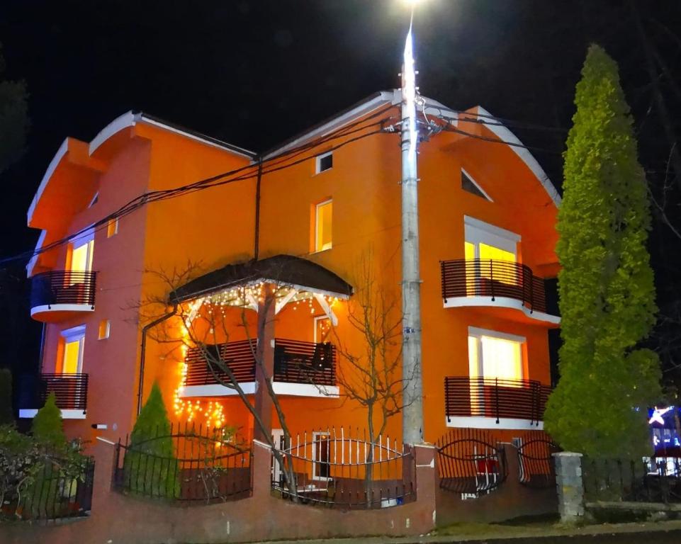 卡夫尼克Casa Iulian的一座橙色的建筑,上面有圣诞灯