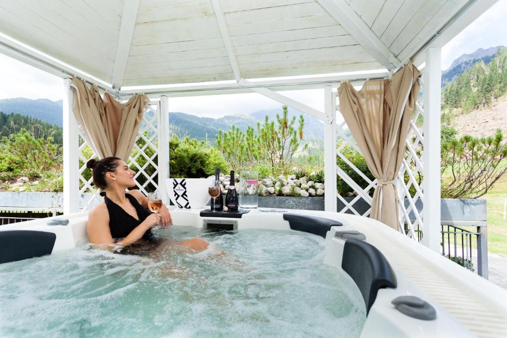 圣马蒂诺-迪卡斯特罗扎维也纳酒店的坐在庭院按摩浴缸中的女人