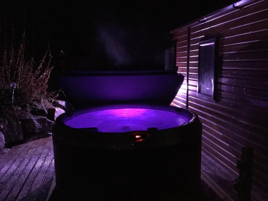 阿维莫尔Cairn View Chalet的晚上在后院的按摩浴缸