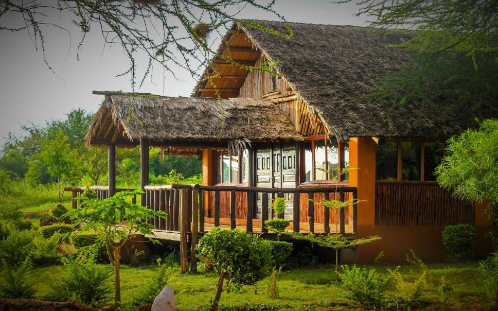 安博塞利Teen Ranch Kenya的茅草屋顶的小房子