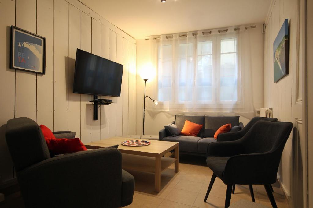 埃特勒塔Au bonheur d'Etretat的客厅配有沙发、椅子和电视