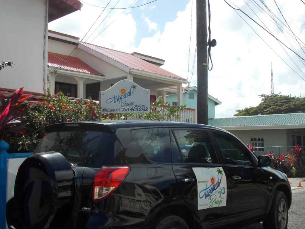 格罗斯岛Tropical Breeze Vacation Home and Apartments的停在大楼前的一辆黑色汽车