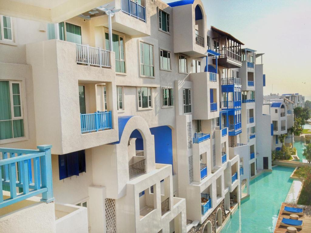 考陶Chelona huahin beachfront condominium的公寓大楼设有蓝色的阳台和游泳池