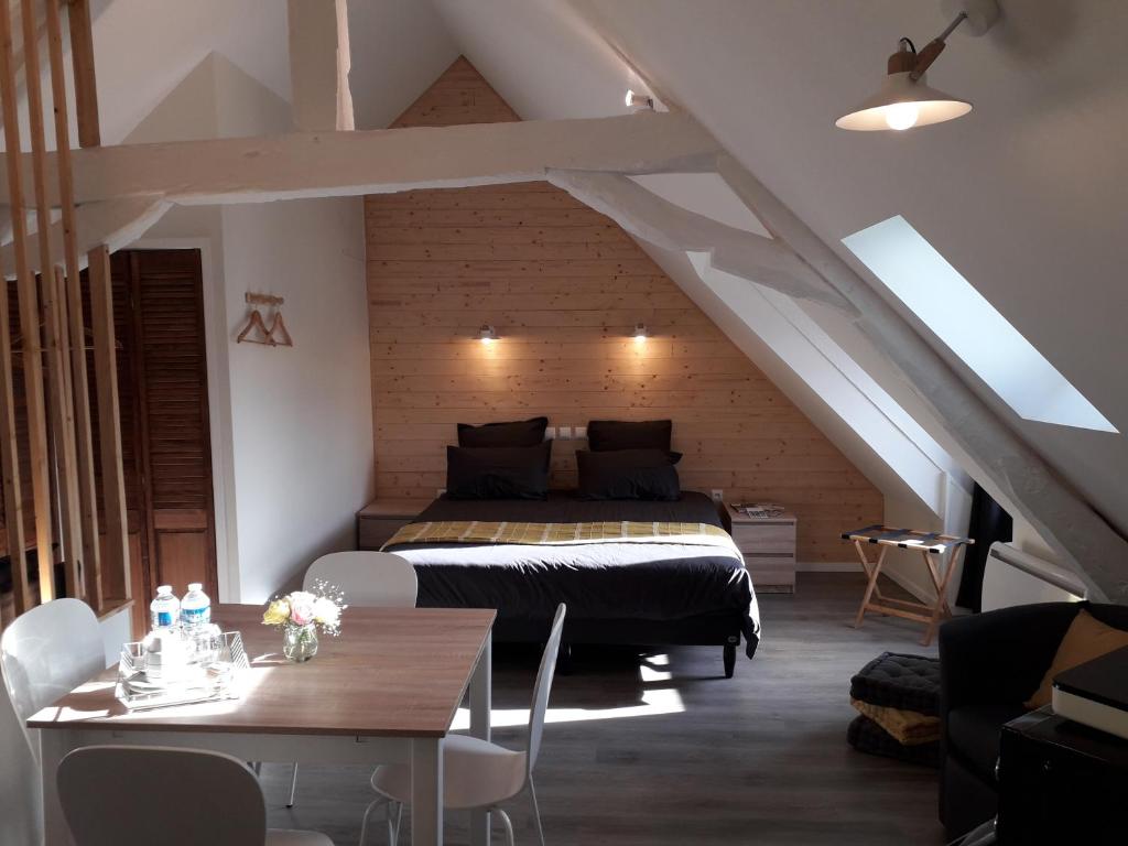 蒙吕松CHARMES EN VILLE Le Charme Authentique的卧室配有一张床和一张桌子