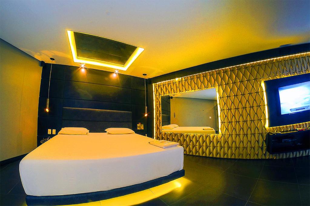 累西腓Nexos Motel Tamarineira (Adult Only)的一间卧室配有一张床和一台电视。