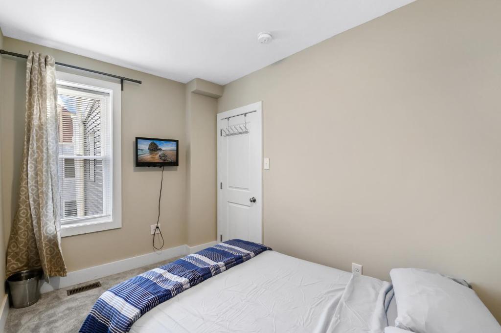 费城Luxury Rooms near Temple U, Drexel, UPenn, and the MET的卧室配有白色的床和窗户。