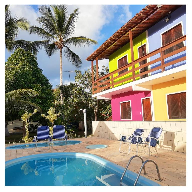 伊列乌斯Pousada Villa Graciela的房屋设有椅子,前面设有游泳池