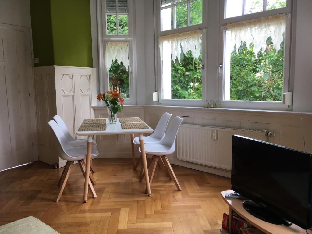 耶拿Appartment im Villenviertel的一间带桌椅和窗户的用餐室