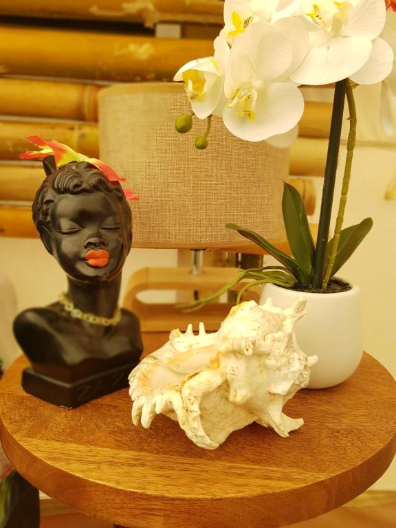 凯里凯里The Luxury Honolulu with Private Bar at Paradise Valley Glamping的一张桌子,上面有雕像,植物和鲜花
