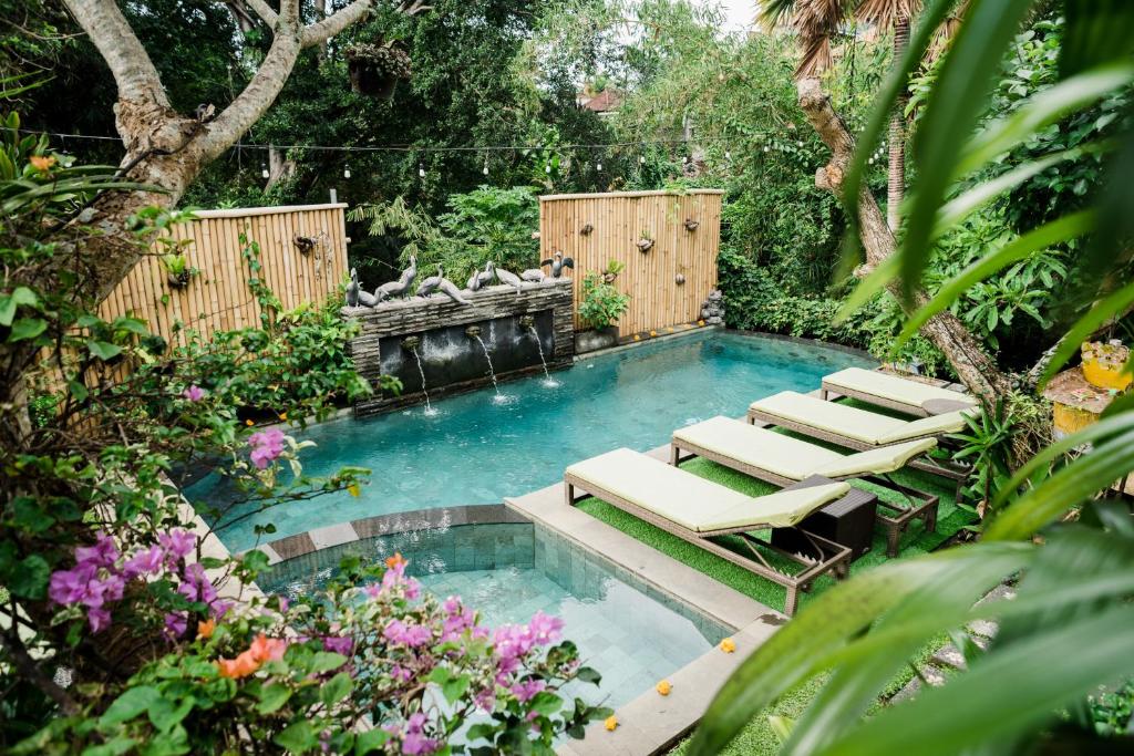 乌布普图王之子避世旅馆的花园内带躺椅的游泳池