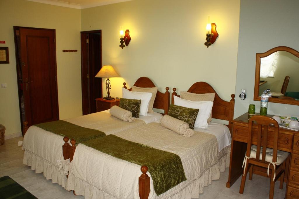 拉戈斯维拉安缇达酒店的一间卧室配有一张床、一张书桌和一面镜子