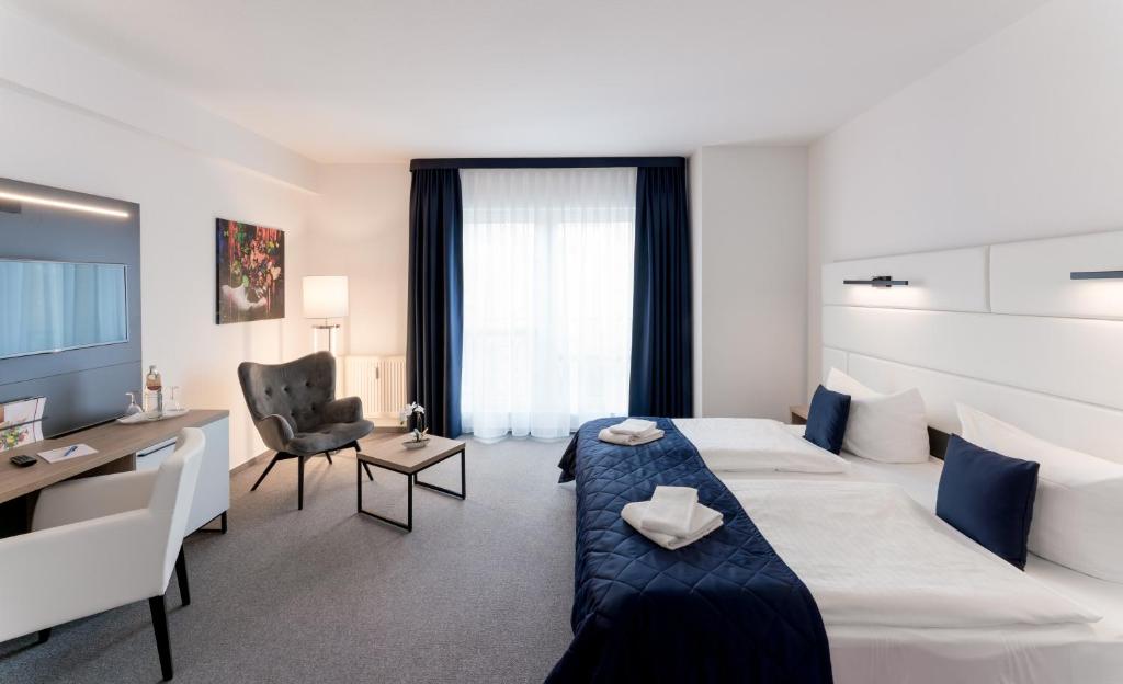 马格德堡斯塔德特菲尔德酒店的酒店客房设有一张大床和一张书桌。