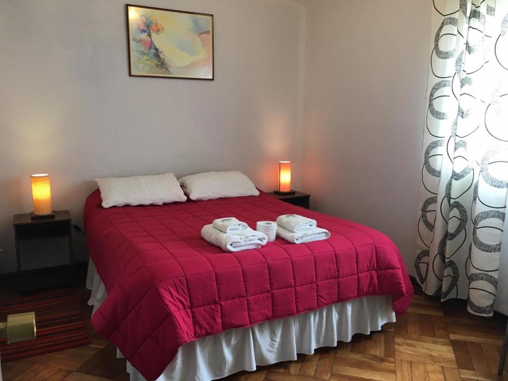 维纳德马Viña Colores的一间卧室配有红色的床和毛巾
