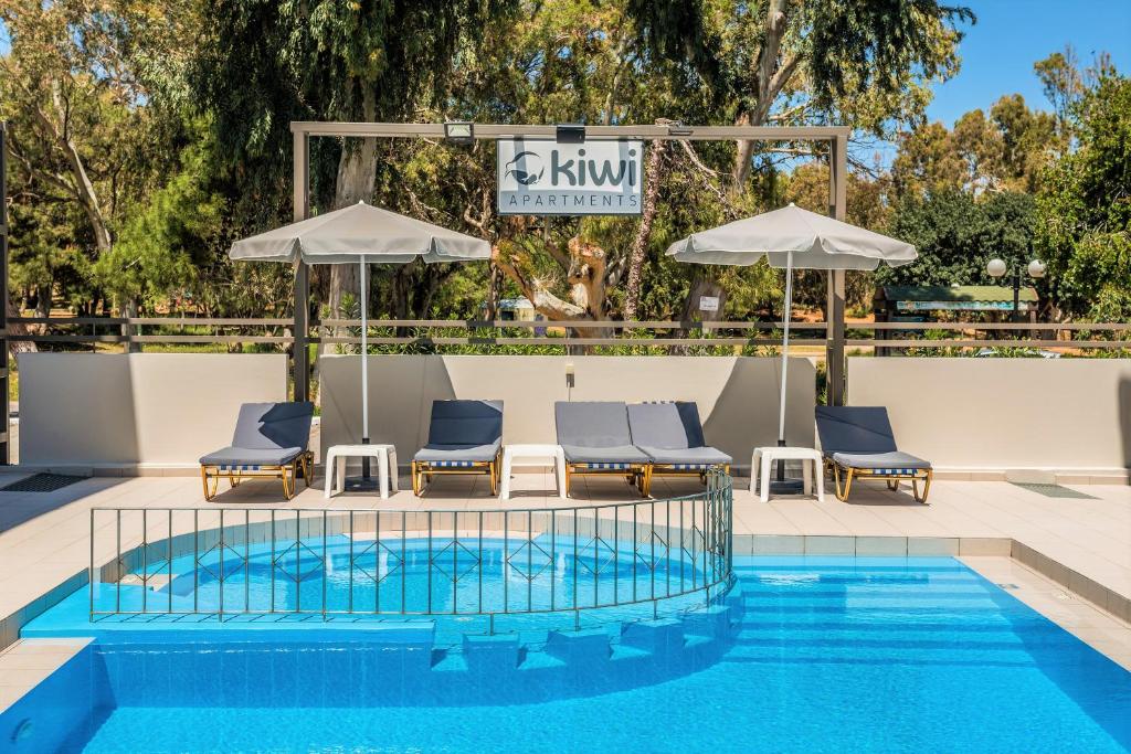 加藤-达拉特索Kiwi Apartments的游泳池,带椅子和遮阳伞