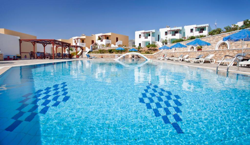 阿尔卡萨Golden Sun Apartments的一个带椅子和遮阳伞的大型蓝色游泳池