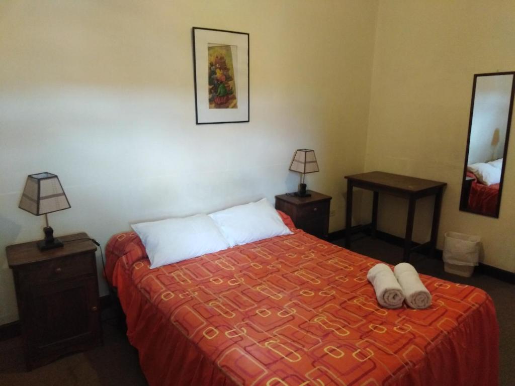 库斯科埃尔图科酒店的一间卧室配有一张带两张桌子和两盏灯的床。
