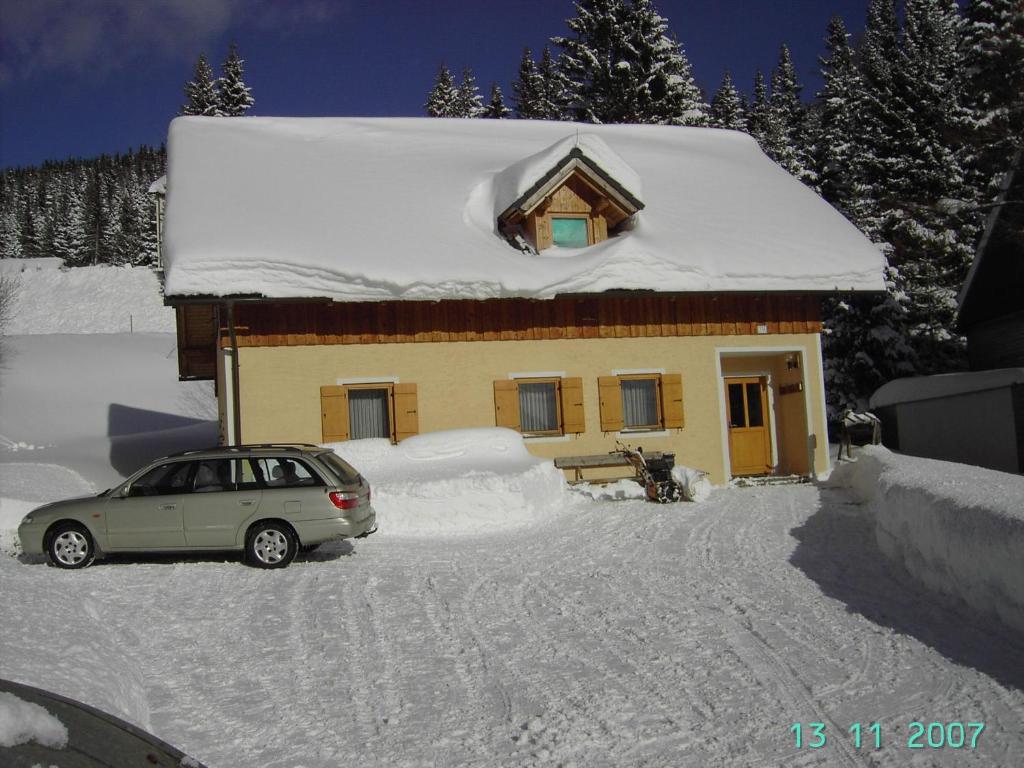 拉赫塔尔Ferienwohnung A 55 m2的停在雪覆盖的房子前面的汽车