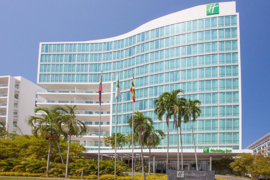 卡塔赫纳卡塔赫纳莫罗斯假日酒店的一座高大的建筑,前面有棕榈树