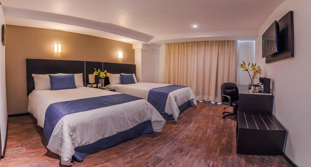 提瓦坎Hotel Zenith的酒店客房设有两张床和电视。