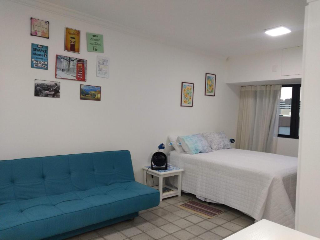 萨尔瓦多Studio perto do Cristo carnaval circuito ondina的一间卧室配有一张床和一张蓝色的沙发