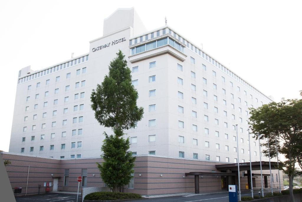 成田成田捷得威大飯店的前面有棵树的白色建筑
