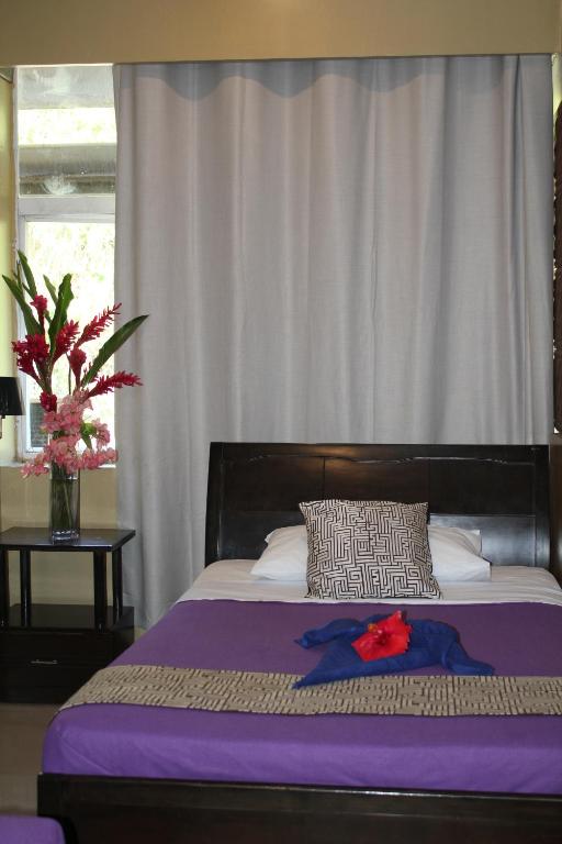 维拉港City Lodge的紫色毯子和花瓶的床