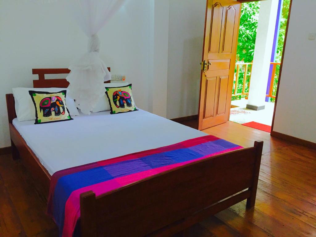 锡吉里亚锡吉里彩虹山林小屋的木地板客房的一张床位
