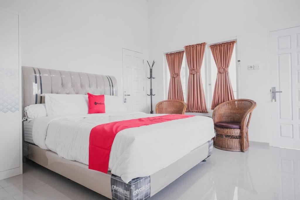 占碑市RedDoorz Syariah near Arafah Hospital Jambi的白色卧室设有一张红色色调的大床