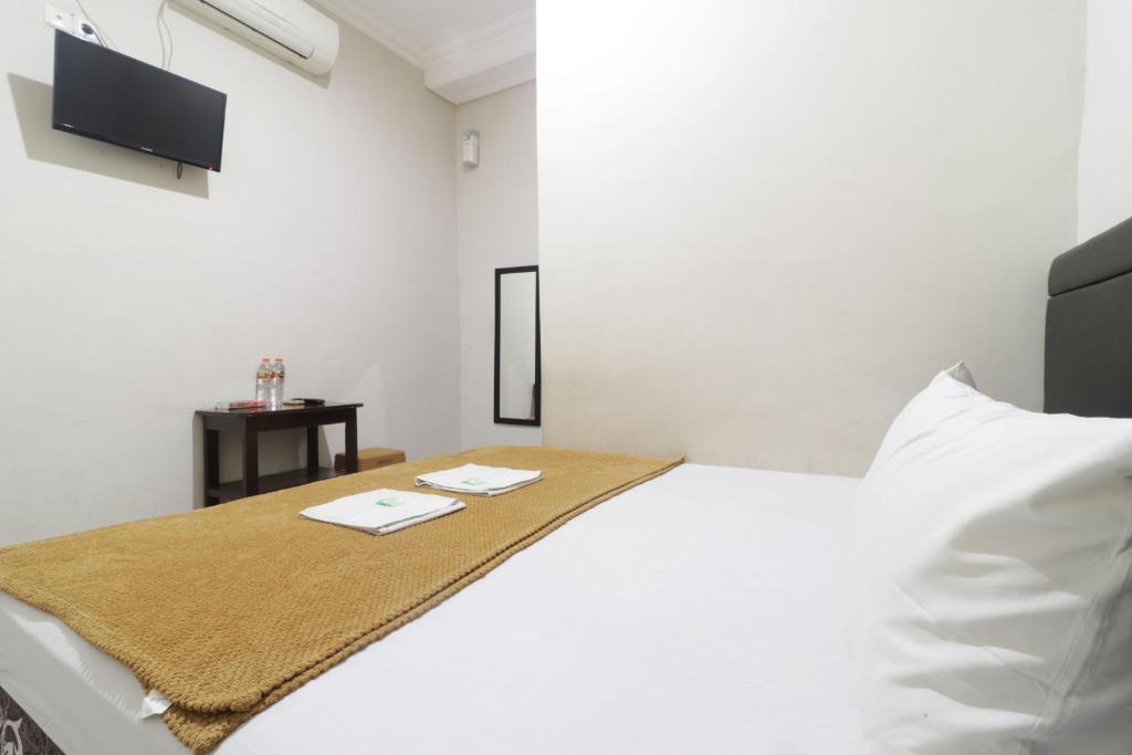 SukodonoHotel Omah Ampel Syariah的白色卧室配有床和桌子