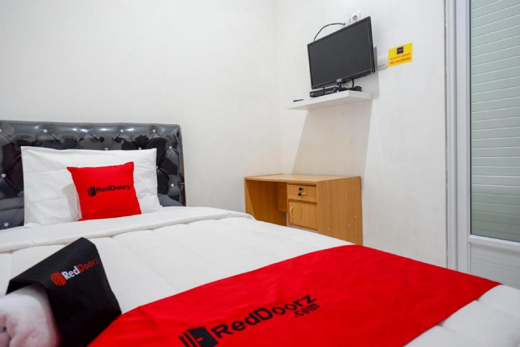三宝垄RedDoorz Hostel near Kota Lama Semarang的卧室配有红色毯子,位于床上