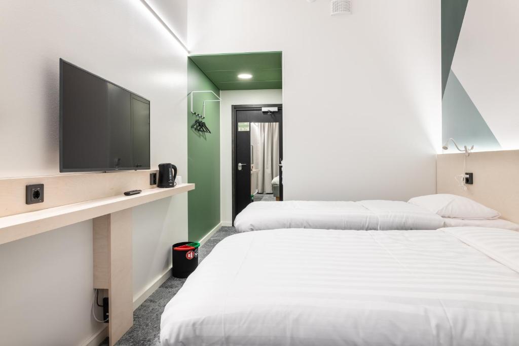 瓦萨GreenStar Hotel Vaasa的配有平面电视的客房内的两张床
