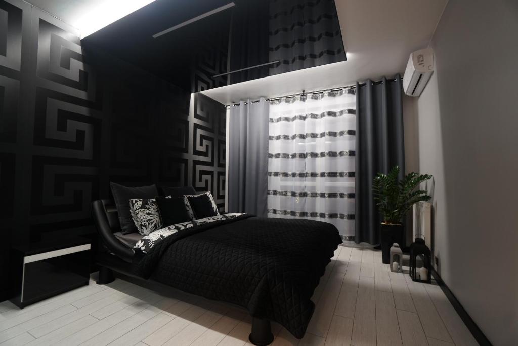 克拉科夫Apartament Lema Versace的一间卧室设有一张黑色的床和一个窗户。