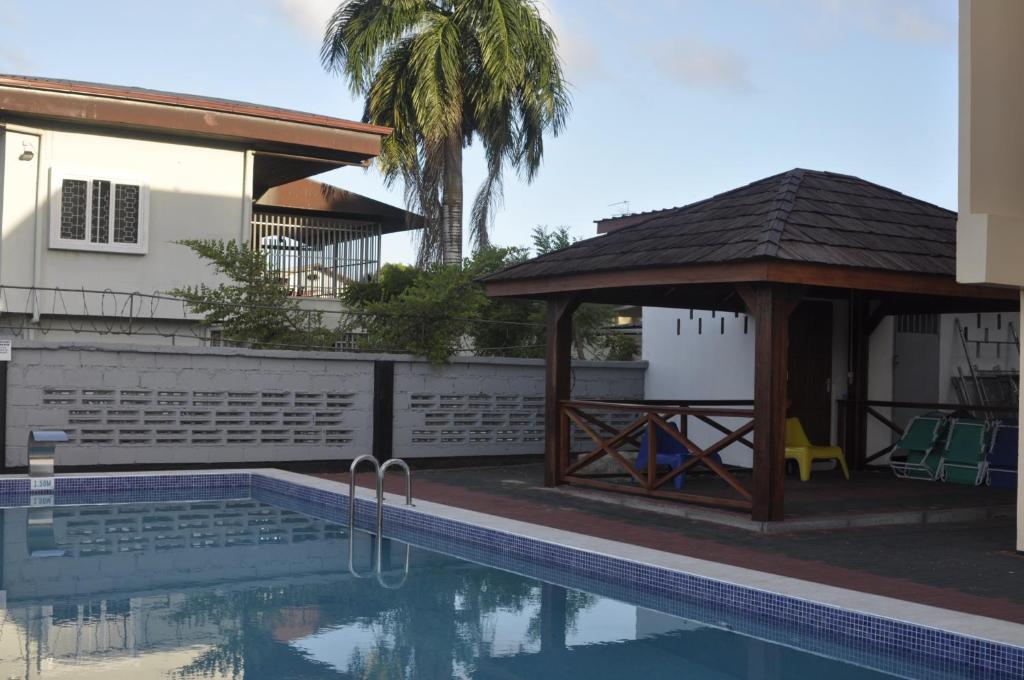 帕拉马里博Riando appartement Royal Rainville的一座游泳池和一个凉亭,毗邻一座房子