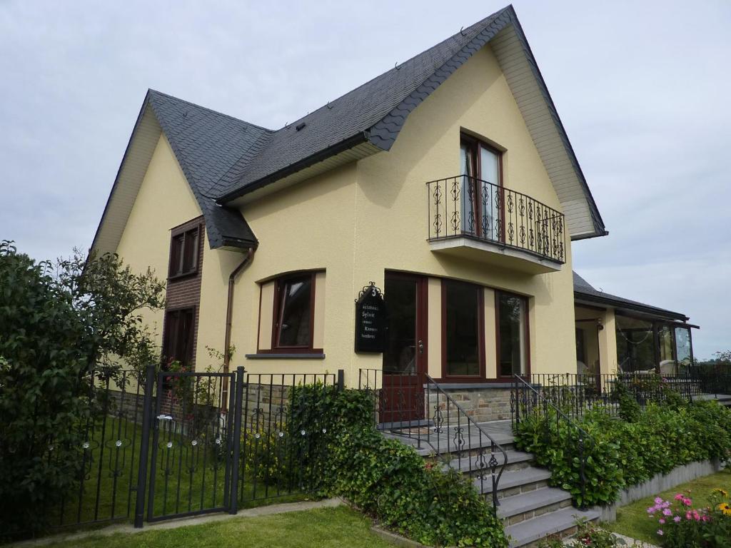 维维尔切Gästehaus Sylvie的黑色屋顶的黄色房子