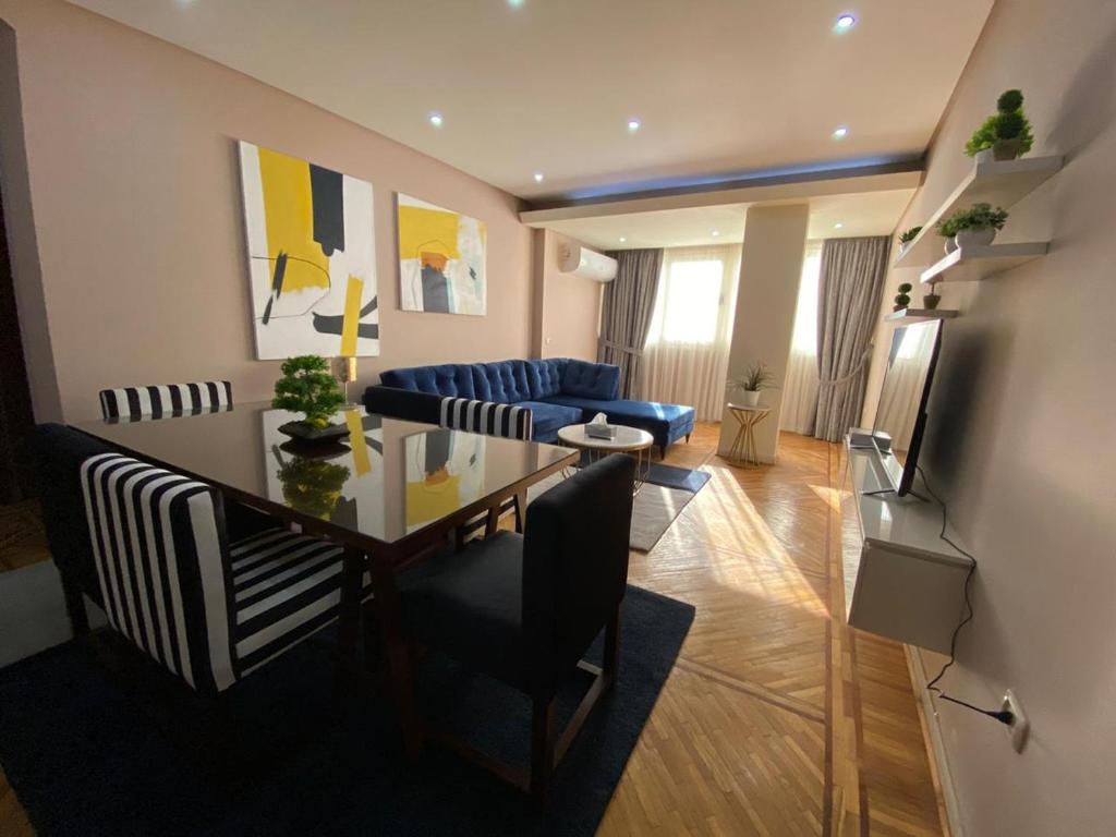 开罗Maspero Nile View Serviced Apartments by Brassbell的客厅配有桌子和蓝色沙发