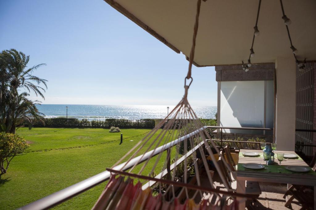 加瓦Gavamar Castelldefels Beachfront Apartment- Direct access to the beach的阳台设有吊床,享有海景。