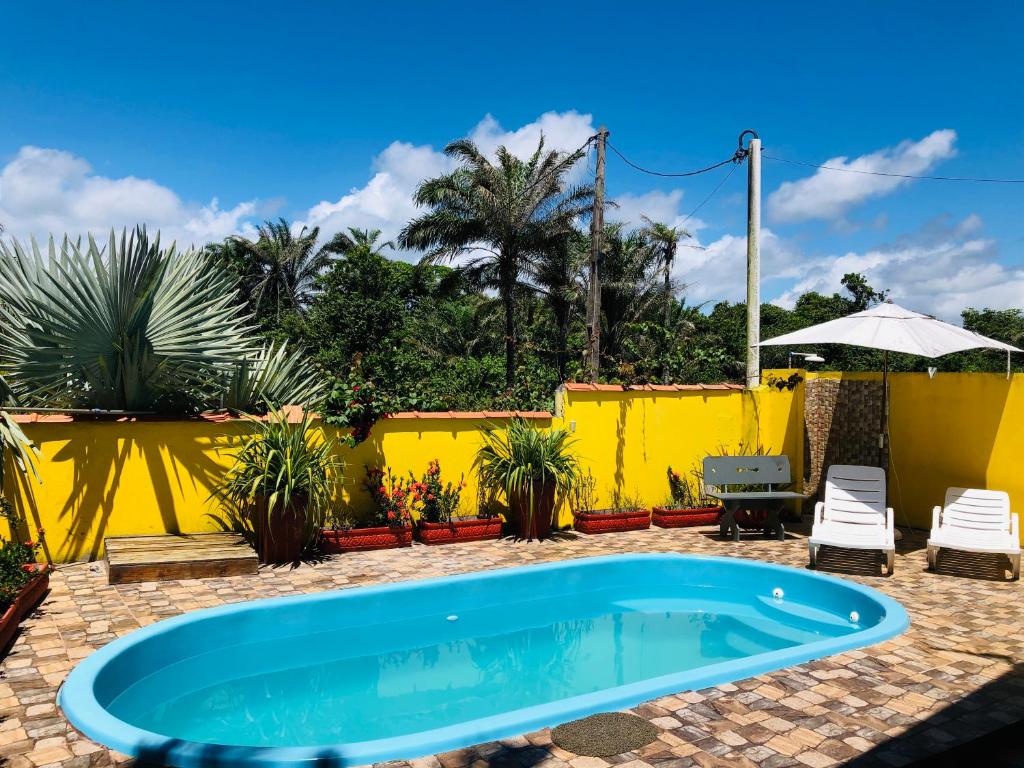 伊列乌斯Casa Amarela na praia para 13 pessoas的一座游泳池,位于一个拥有黄色围栏的庭院内